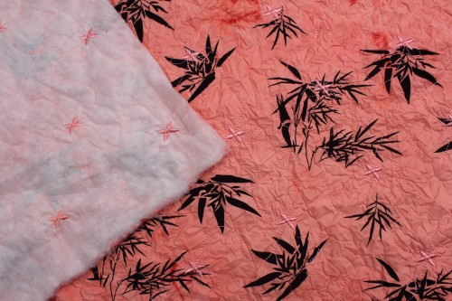 tkanina pikowana z ociepleniem w kolorze łosoś w czarne kwiaty